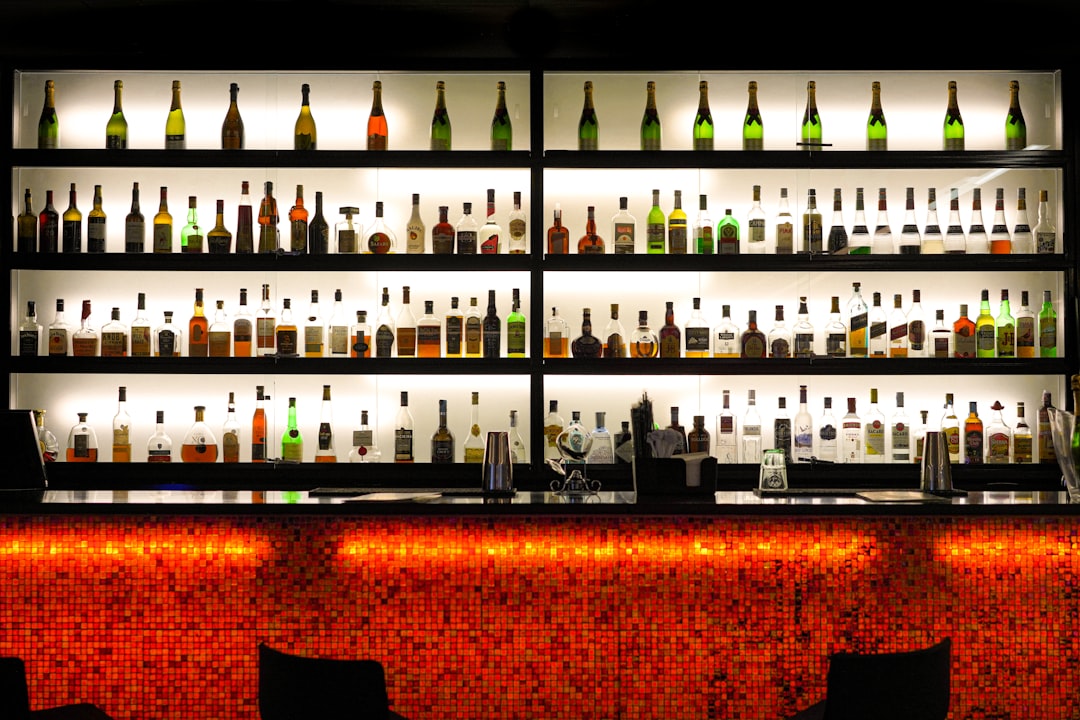 A wooden bar shelf lined with whisky bottles
