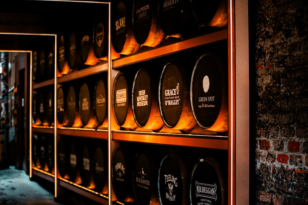 Rows of whisky casks stacked on shelves in a maturation warehouse