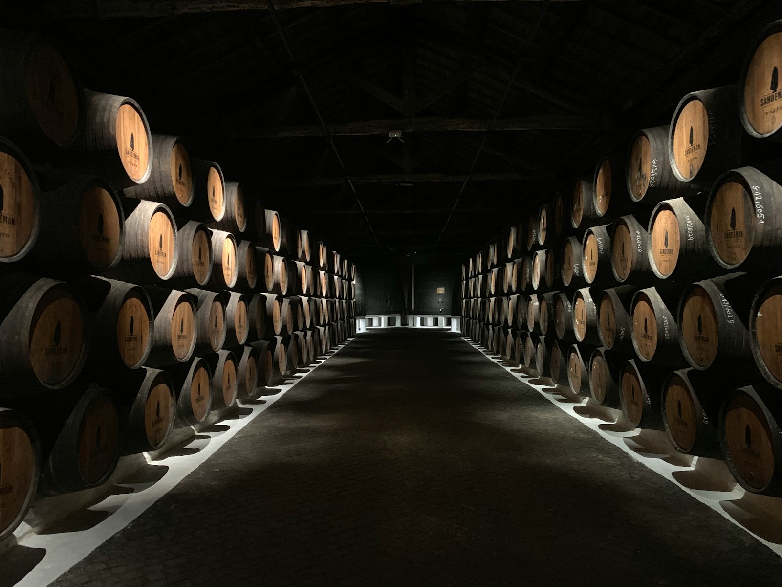Rows of oak whisky casks stacked on their sides in a dunnage warehouse