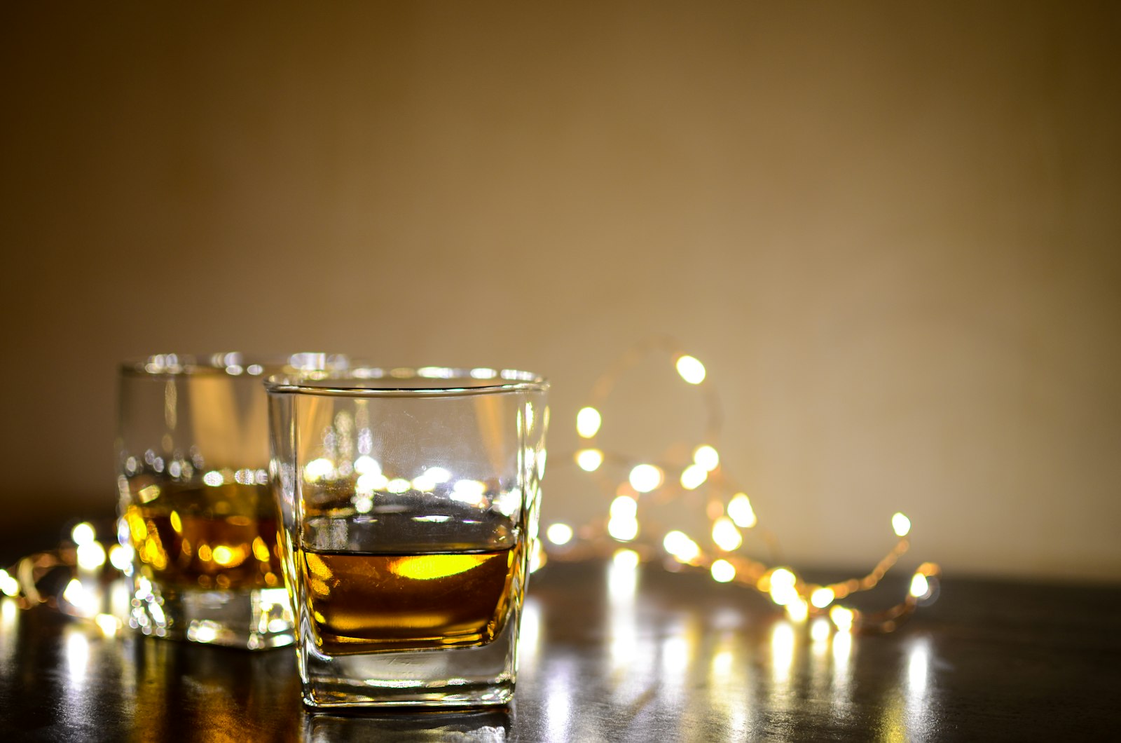 A glass of amber whisky on a wooden table