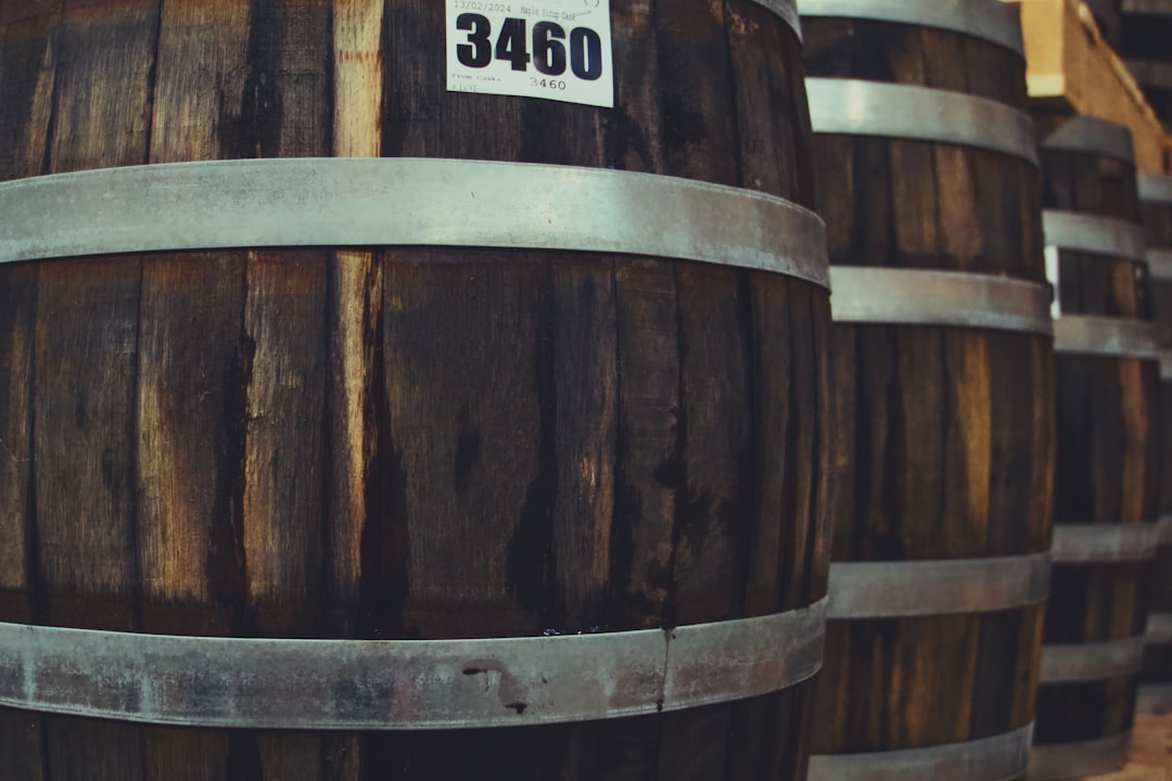 A row of wooden whisky casks stacked in a distillery warehouse